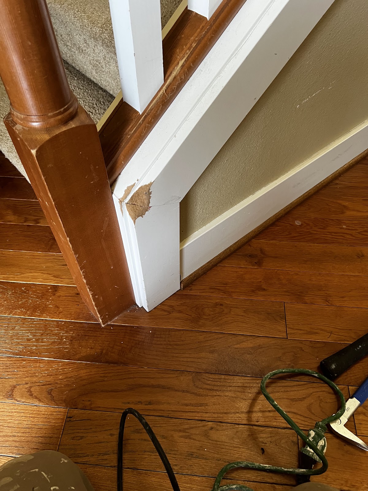 Stair trim and baseboard carpentry repair, close detail